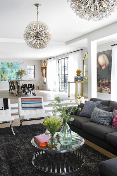 Light fixtures and an area rug in one section of the space designed by The Novogratz, help break it i